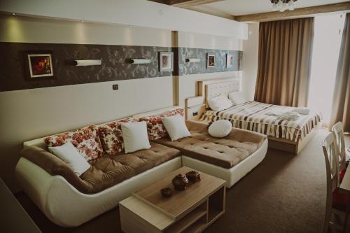 a living room with a couch and a bed at MILMARI CENTRAL Private apartments in Kopaonik