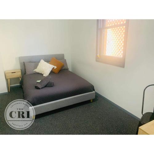 ein kleines Bett in einem Zimmer mit Fenster in der Unterkunft Criterion Hotel Grenfell in Grenfell