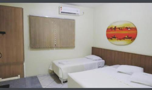 a room with two beds and a window at Hotel Casa Nova in Várzea Grande