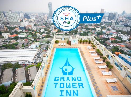 a sign on the top of a building with a pool at Grand Tower Inn Rama 6 in Bangkok