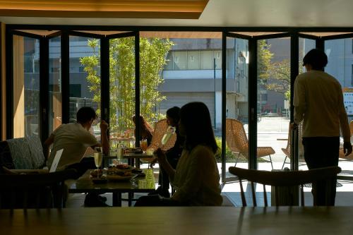 a group of people sitting at a table in a restaurant at FAV HOTEL KUMAMOTO in Kumamoto