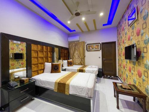 a hotel room with two beds and a tv at Horizon Hotel in Lahore