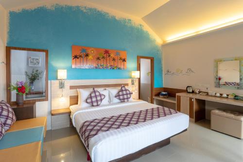 a bedroom with a large bed and a blue wall at Palm Coco Mantra in Lamai