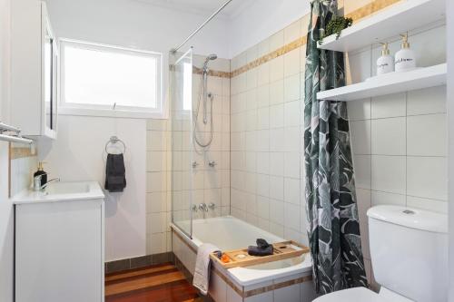 La salle de bains est pourvue d'une baignoire, de toilettes et d'un lavabo. dans l'établissement Artist's Cottage - Cosy Home in Quiet Leafy Street, à Toowoomba