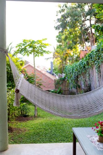 a hammock in a yard with a house at Palm Coco Mantra in Lamai