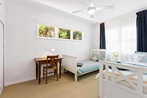 a bedroom with a desk and a bed and a table at Artist's Cottage - Cosy Home in Quiet Leafy Street in Toowoomba