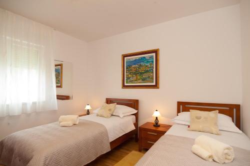 a bedroom with two beds and a window at Apartments Maja in Omiš