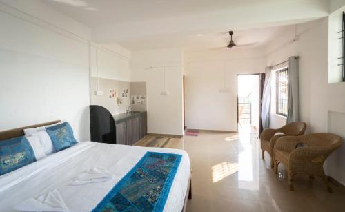 a bedroom with a large bed and chairs in it at De Lavender Luxury sea view Guest Houses in Agonda