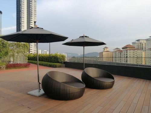 duas cadeiras e guarda-sóis sentados num telhado em The Ridge @ KL East Mall & Condominium em Kuala Lumpur
