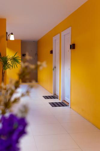 an empty hallway with yellow walls and doors at Palm Coco Mantra in Lamai