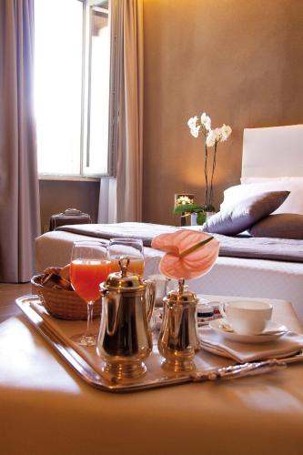 a tray with drinks on a table next to a bed at Hotel San Rocco in Orta San Giulio