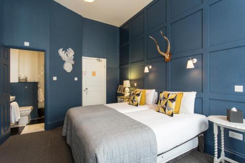 - une chambre avec un grand lit et des murs bleus dans l'établissement Georgian House Hotel, à Londres