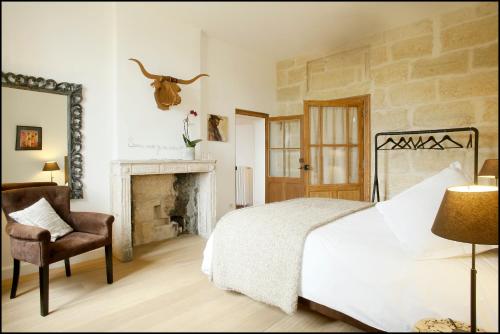une chambre avec un lit et une cheminée dans l'établissement La Maison Rouge d'Uzes B&B, à Uzès
