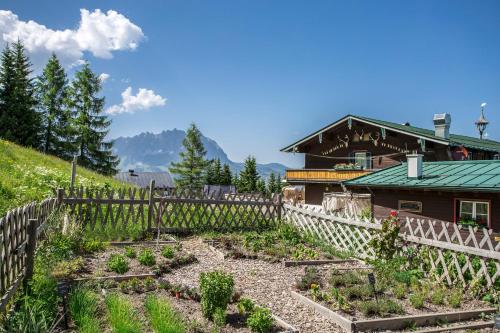 um jardim em frente a uma casa com uma cerca em Angerer Alm em Sankt Johann in Tirol