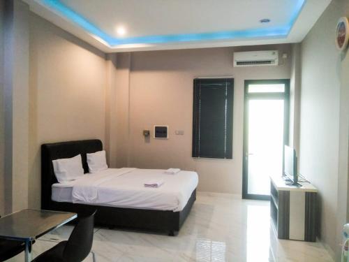 1 dormitorio con 1 cama, TV y mesa en Mandabelle Villa 1 room en Citeureup