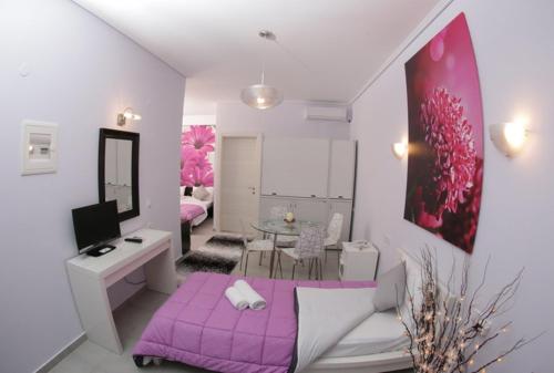 a living room with a purple bed and a table at Studios Ioulia in Keramot&iacute;