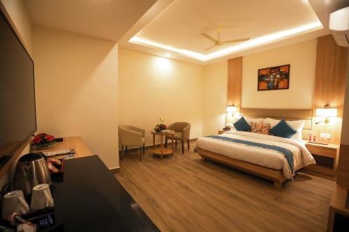 ラクナウにあるElora Lords Eco Inn , Lucknowのベッドとデスクが備わるホテルルームです。
