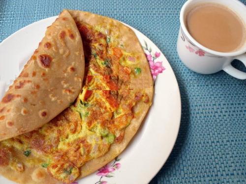 a pizza on a plate next to a cup of coffee at Horizon Hotel in Lahore