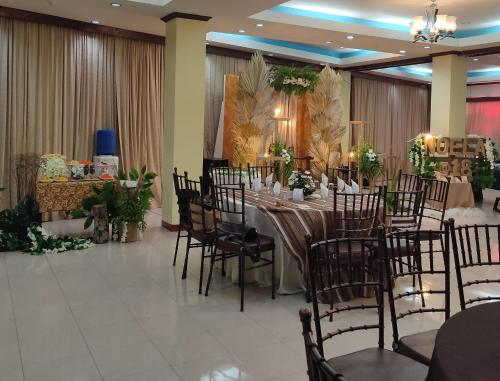 un salón de banquetes con una mesa larga y sillas en Fiesta Ballroom Hotel, en Legazpi