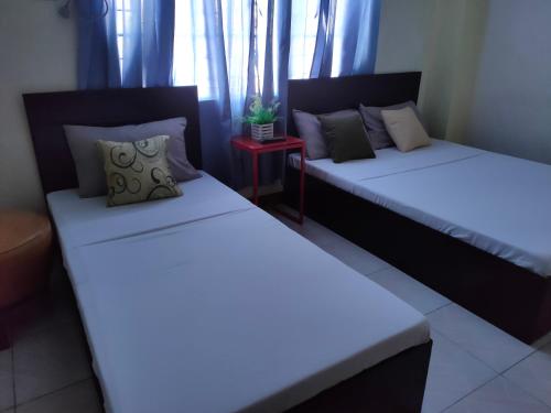 two beds sitting next to each other in a room at Fiesta Ballroom Hotel in Legazpi