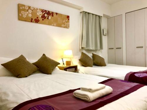 Dos camas en una habitación de hotel con toallas. en リブシティ錦糸町参番館上層階スカイツリーの眺望 en Tokio