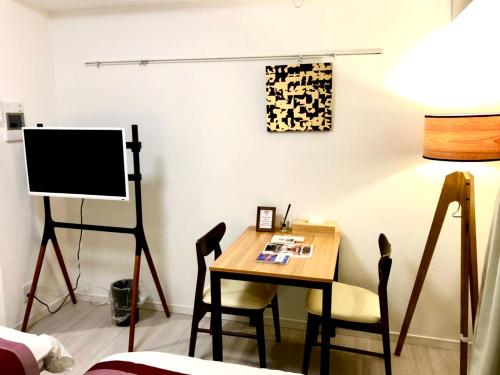a room with a table and chairs and a television at リブシティ錦糸町参番館上層階スカイツリーの眺望, Akihabara 6 mins, Tokyo Station 8 mins, Direct to Narita Airport 成田空港直達 in Tokyo