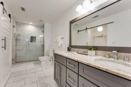 a bathroom with a sink and a toilet and a mirror at Luxury Atlanta Home - Self Check-in Pet Friendly Free Parking in Atlanta