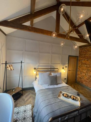 a bedroom with a large bed with a brick wall at The Secret Cottage - Morpeth in Morpeth