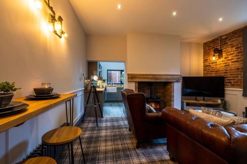 a living room with a couch and a fireplace at The Secret Cottage - Morpeth in Morpeth