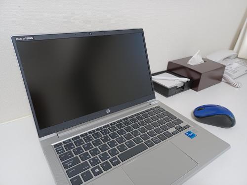 a laptop computer sitting on a desk with a mouse at Akasaka Urban Hotel in Tokyo