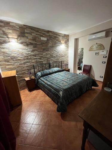 a bedroom with a bed and a stone wall at B&B San Domenico in Realmonte