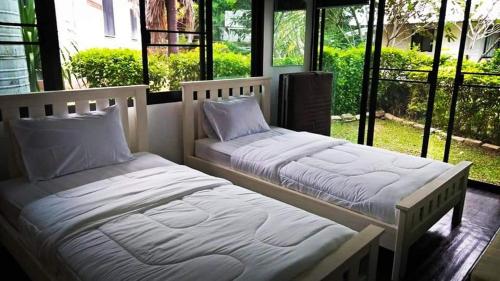 two beds sitting next to each other in a room at The Balcony pool villa in Ban Khanong Phra Nua