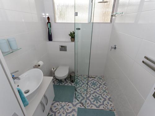 a bathroom with a shower and a toilet and a sink at Ocean-Song in Strand