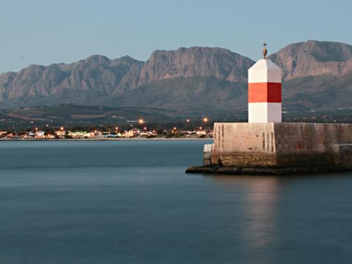 a red and white lighthouse on a island in the water at Ocean-Song in Strand