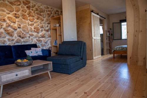 uma sala de estar com uma cadeira azul e uma parede de pedra em Cozy Galilee Getaway em Abirim