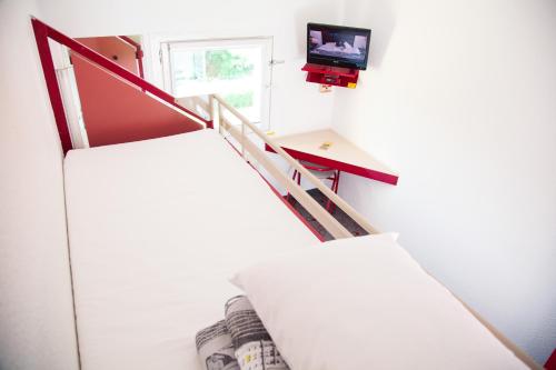 eine Treppe in einem Zimmer mit einem TV am Fenster in der Unterkunft Class'eco Charleroi in Charleroi