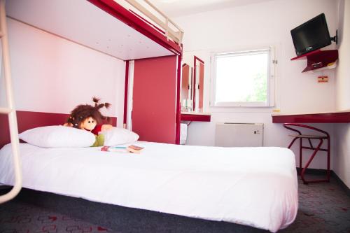 a young girl laying on a bed in a bedroom at Class'eco Charleroi in Charleroi