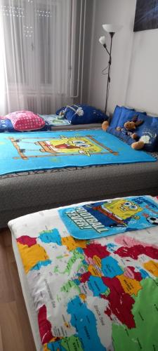 two twin beds in a bedroom with colorful blankets at ANKER SILVER DREAM in Kaposvár