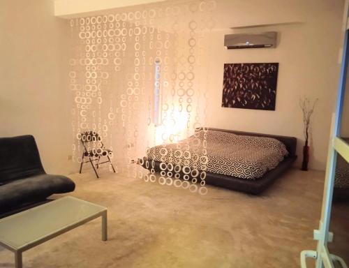 sala de estar con cama y silla en Loft 9 en el centro de Cancún, en Cancún