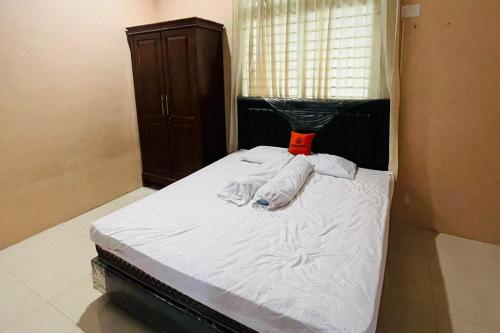 1 dormitorio con 1 cama con sábanas blancas y ventana en KoolKost @ Jalan Polonia Medan (Minimum Stay 6 Nights), en Medan