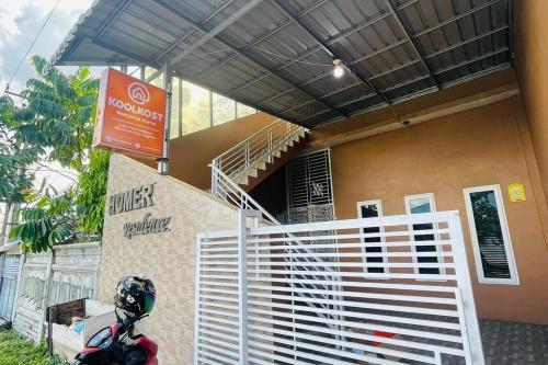 棉蘭的住宿－KoolKost @ Jalan Polonia Medan (Minimum Stay 6 Nights)，停在有楼梯的建筑前面的摩托车