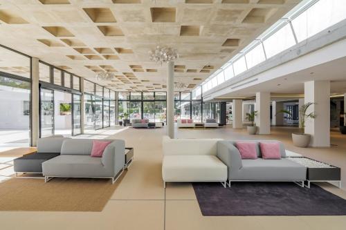 eine große Lobby mit zwei Sofas und Fenstern in der Unterkunft Els Pins Resort & Spa - Emar Hotels in Bucht von San Antonio