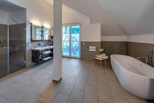 a large bathroom with a tub and a sink at VILLA LINDE Seehotel in Bodman-Ludwigshafen