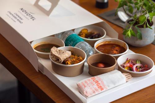 a box filled with different types of food on a table at Novotel Chennai Chamiers Road in Chennai