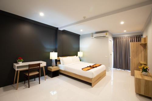 a bedroom with a bed and a table and a desk at 185@Surawong Residence in Bangkok