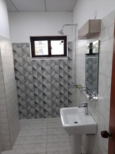 ein weißes Bad mit einem Waschbecken und einem Fenster in der Unterkunft Sultan Executive Hotel in Dargai