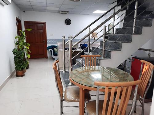 a dining room with a table and chairs and stairs at Sultan Executive Hotel in Dargai