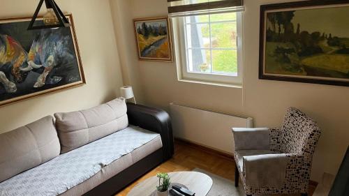 a living room with a couch and a chair at Sunčani Apartman in Brzeće