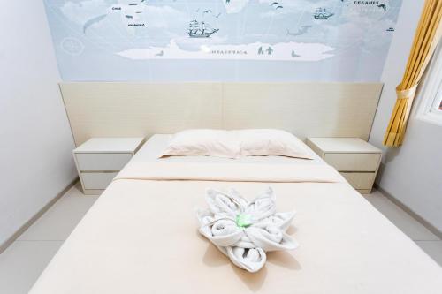 a bedroom with a bed with a flower on it at Batuque Town Villa 2 in Batu