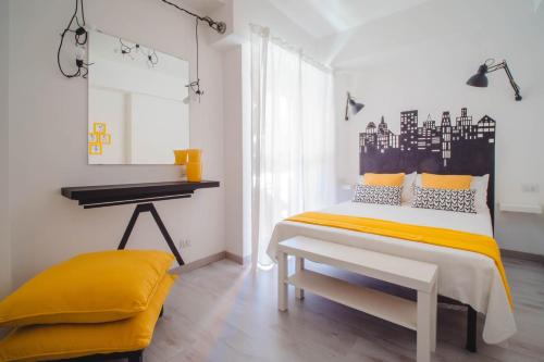 um quarto com uma cama com lençóis amarelos e uma secretária em Lady Butterfly - Metro A Lucio Sestio em Roma